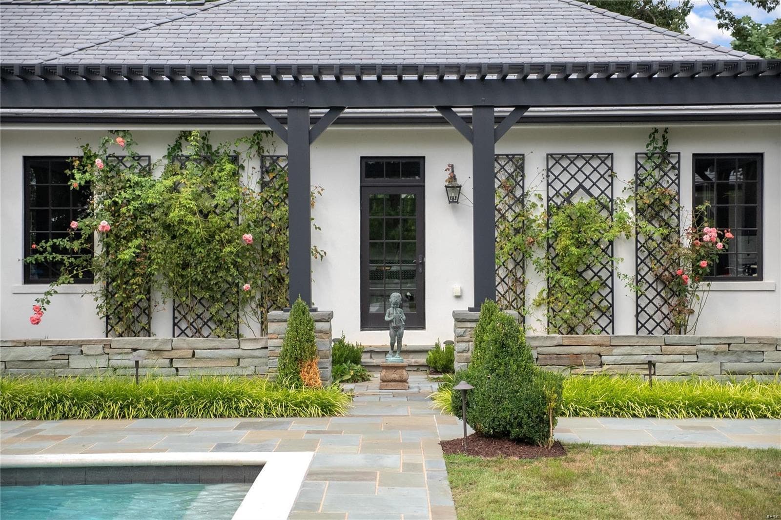 view of outside of a freshly remodeled home door with leaves and bushes